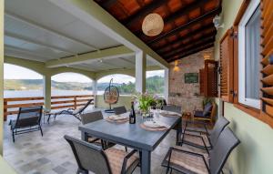 une salle à manger avec une table et des chaises sur une terrasse dans l'établissement Lovely Home In Vela Luka With House Sea View, à Vela Luka