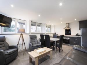 a living room with a table and chairs and a kitchen at Residence Louis Quartier Des Lilas in Vittel