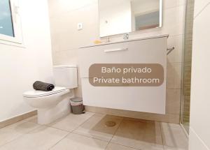 een badkamer met een toilet en een bord met baja pampa eigen badkamer bij Maracuyá by Lovely Property in Corralejo