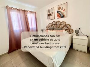 een kamer met een bed met een bord erop bij Maracuyá con piscina, terraza, smart tv, cocina completa y WIFI in Corralejo
