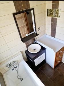 uma casa de banho com uma banheira branca e um lavatório. em Le haut du parc em Gérardmer