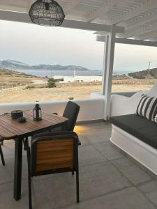 a patio with a table and a couch and a view of the beach at SOPHILIA SUITES in Koufonisia