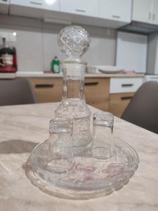 a glass bottle and two glasses sitting on a table at Creta Irini's Rooms2 in Tympáki +37 photos