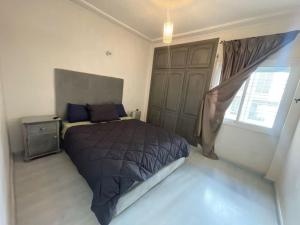 Un dormitorio con una cama grande y una ventana en Appart spacieux en centre-ville en Fez