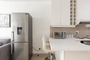 a kitchen with a refrigerator and a white counter top at Breakers 421 in Durban