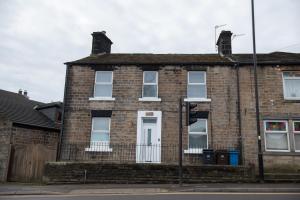 een bakstenen huis met een stoplicht ervoor bij Oak Cottage in Deepcar