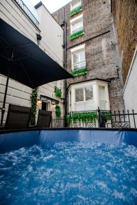 een zwembad met een parasol voor een gebouw bij The Balcony in Ramsgate