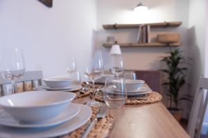 a table with plates and wine glasses on it at Oak Cottage in Deepcar