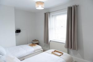 a bedroom with two beds and a window at Oak Cottage in Deepcar