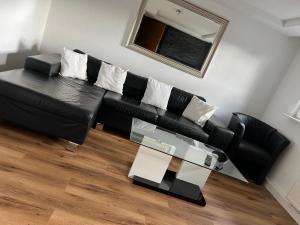 a black leather couch in a living room with a table at Ferienwohnung Eislingen in Eislingen