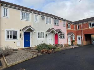 een rij witte huizen met rode en blauwe deuren bij 2 Bed House Nr Shrewsbury Hospital in Bicton
