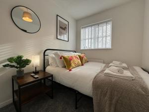 een slaapkamer met een bed en een tafel met een spiegel bij 2 Bed House Nr Shrewsbury Hospital in Bicton