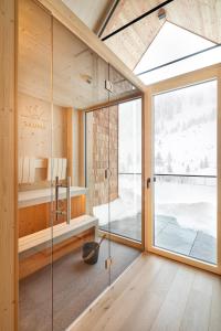 a glass shower in a bathroom with a window at Apparthotel Sonne in Obertauern
