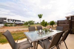 ゲラキニにあるHarry Sea Side Family Apartment, Gerakiniのダイニングテーブルと椅子付きのパティオ
