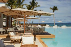 een zwembad met stoelen, tafels en parasols bij Cayo Levantado Resort - All Inclusive in Santa Bárbara de Samaná