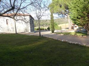 einen Hof mit einem Haus und einem Grasfeld in der Unterkunft El Rodenal in Valera de Abajo