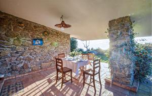 Ioppolo的住宿－Beautiful Home In Joppolo With Wi-fi，一个带石墙的庭院里的桌椅