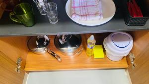 a wooden shelf in a kitchen with dishes on it at Kitinete Mobiliada in Chapecó