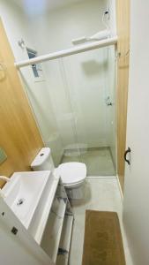 a bathroom with a toilet and a sink and a shower at Kitinete Mobiliada in Chapecó +1 photo