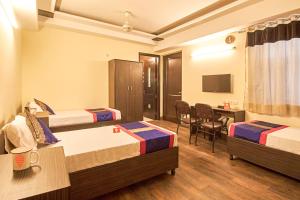 a hotel room with two beds and a desk at OYO 3594 Kamla Nagar in New Delhi