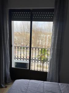 ventana del dormitorio con vistas a un balcón en APARTAMENTOS LEONOR, en Baeza