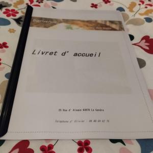 a book with a letter on top of a table at Bienvenue in Le Cendre