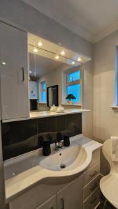 a bathroom with a sink and a mirror at Ards House Self catering apartment with sea views in Oban +7 photos