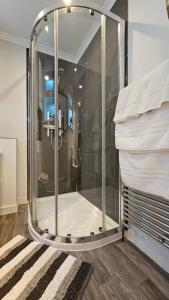 a glass shower in a room with a pile of towels at Ards House Self catering apartment with sea views in Oban