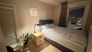 a small bedroom with a bed and a window at Strandvegen 110A in Tromsø