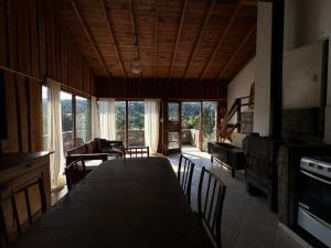 a dining room with a table and chairs and a living room at Casa La Boticaria in La Cumbrecita
