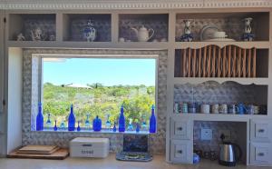 a window in a kitchen with blue glass bottles at Stone Crown Manor B&B in Mossel Bay