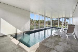 a swimming pool in a house with a large window at Rocha do Mar 1 in Biscoitos