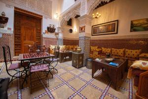 a living room with a couch and a table at Riad Le Petit Patrimoine De Fés in Fès
