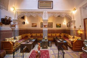 Habitación grande con sofás y mesas en un edificio en Riad Le Petit Patrimoine De Fés en Fez