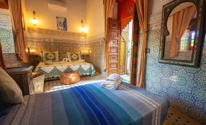 a bedroom with two beds and a mirror at Riad Le Petit Patrimoine De Fés in Fès