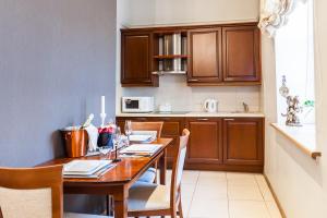 eine Küche mit einem Holztisch mit Stühlen in der Unterkunft Central apartments 2 x Free Parking x SELF CHECK-IN 24h by H&H in Vilnius