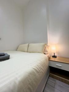 a bedroom with a bed and a desk with a lamp at Warm 1-bedroom London apartment in London