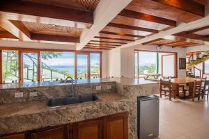 a kitchen with a sink and a table and some windows at Party house for family! in Tarcoles