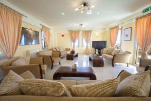 a large living room with couches and a tv at Belle View Hotel - Sea View & Sunset in Mánganos