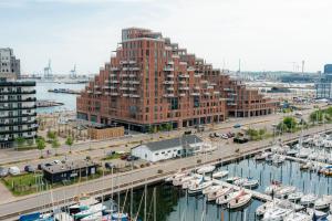 um grande edifício de tijolos vermelhos ao lado de uma marina com barcos em Seaside apartment with magical balcony view em Arhus