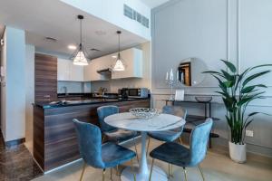 a kitchen and dining room with a table and chairs at GuestReady - Out of the Blue in Dubai