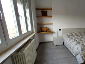 1 dormitorio con cama, radiador y ventana en Sesto Piano Apartment en Asti