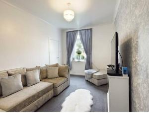 a living room with a couch and a tv at Work & Relax - 2 bedroom house with off-road parking in Swansea