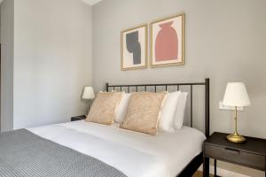 a bedroom with a bed with white sheets and pillows at Blueground Poblenou pool nr Glories BCN-37 in Barcelona