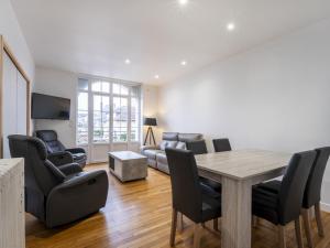 sala de estar con mesa, sillas y sofá en Residence Louis Quartier Des Lilas en Vittel