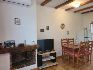 a living room with a table and a television and a kitchen at Floridasol in Denia