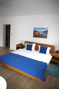 a bedroom with a large bed with blue pillows at English House in Bistriţa
