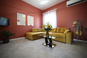 a living room with a couch and a table with flowers at Ε121 Luxury Suites in Edessa