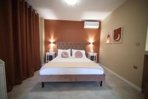 a bedroom with a large bed with two pink pillows at Ε121 Luxury Suites in Edessa