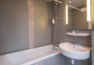 een badkamer met een wastafel en een bad bij Grand Hôtel De Turin in Parijs